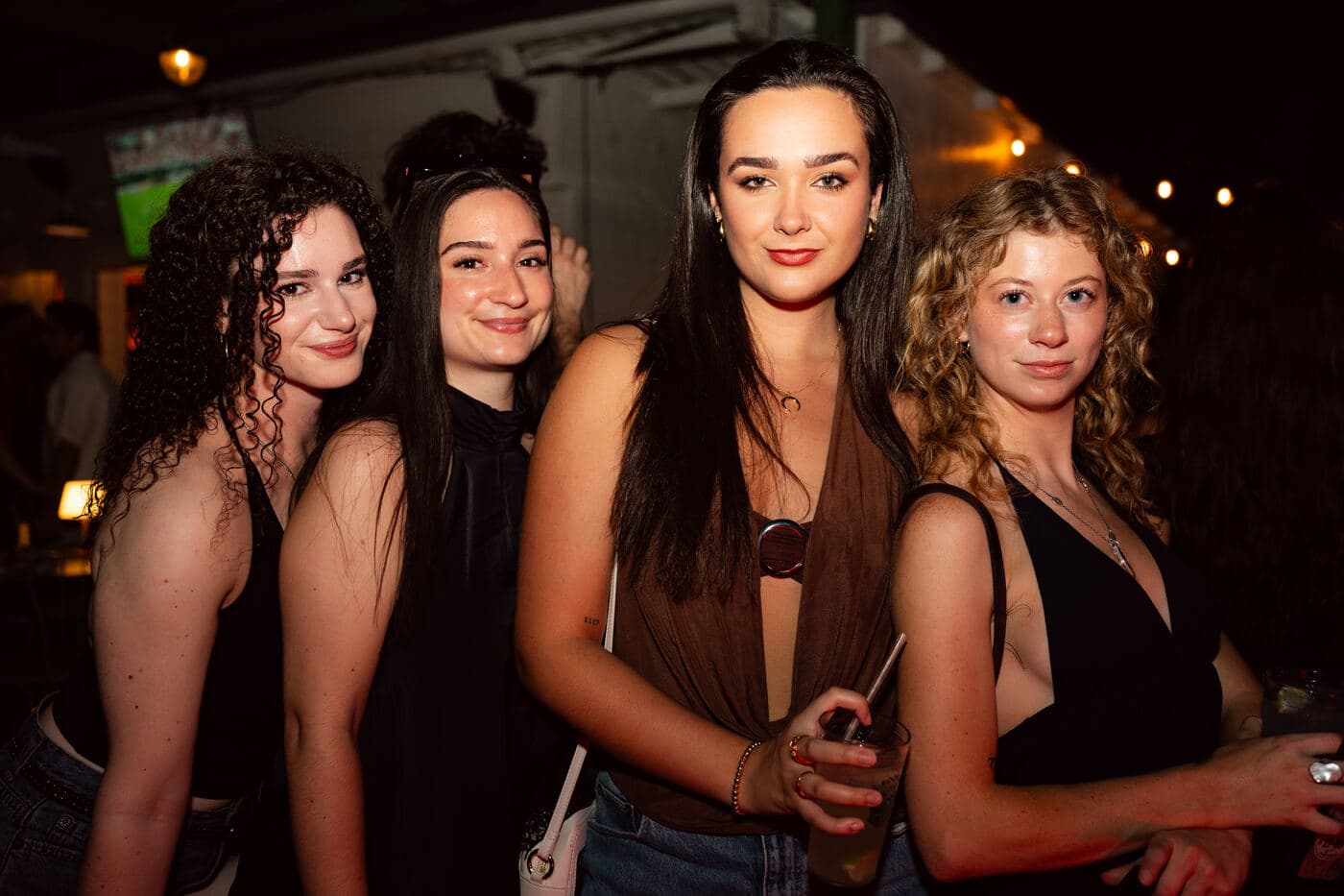 Four friends posing together at the bar before the set
